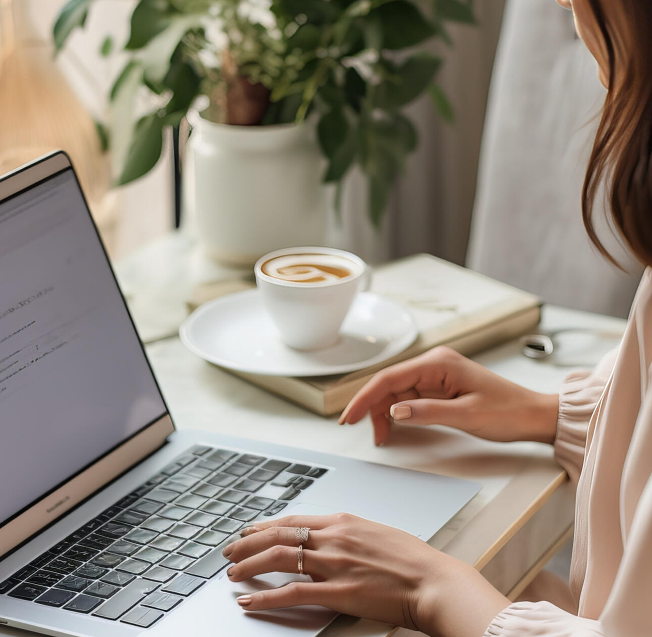using laptop at desk with a cup of coffee